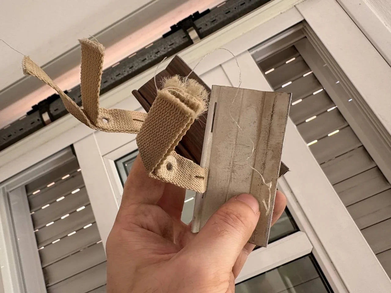 Old frayed roller-shutter suspension straps after removing them from the shutter